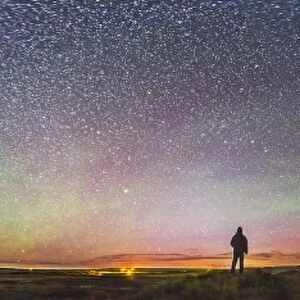 Skygazer standing under the stars at Grasslands National Park, Canada