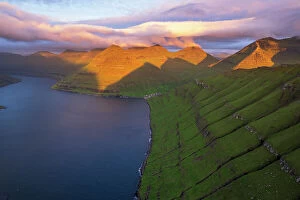 Aerial Views Canvas Print Collection: Aerial shot of the dramatic view of Funningur with pink sky at dawn, Eysturoy island
