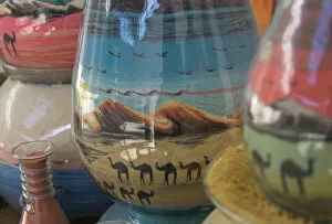 Contemporary art Collection: Close up of sand bottles with camels in landscapes