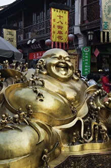 Related Images Metal Print Collection: A golden statue of a reclining laughing Buddha covered in small Buddhas