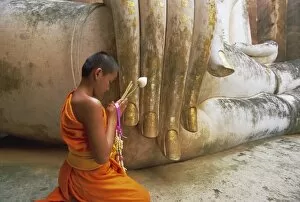 Meditating Collection: Novice Buddhist monk and Phra Atchana Buddha statue