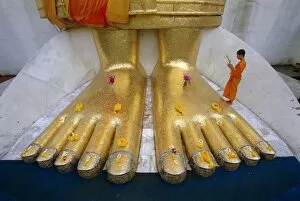 Foot Collection: Novice monk praying at the feet of Giant Buddha statue