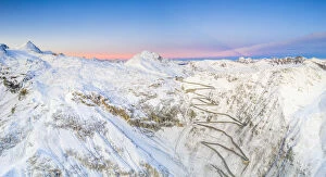 Landscape paintings Cushion Collection: Aerial panoramic of Stelvio Pass and winding road covered with snow at dawn, Bormio