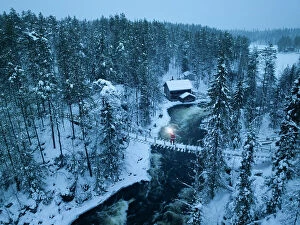 Finland Pillow Collection: Santa Claus with lantern on the suspended bridge above the frozen rapids, Myllykoski, Juuma