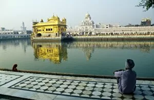 Temples Jigsaw Puzzle Collection: A Sikh pilgrim pauses for reflection by Amrit Sarovar