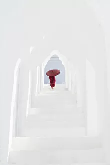 Related Images Framed Print Collection: A young Buddhist monk holding a red umbrella walks up the steps in Hsinbyume Pagoda