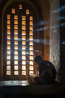 Mandalay Cushion Collection: A young monk studying by a window inside a temple, UNESCO, Bagan, Mandalay Region