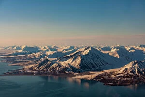 Spitsbergen Island Collection: Sunlight highlights ice covered mountains on Spitsbergen Island, Svalbard, Norway