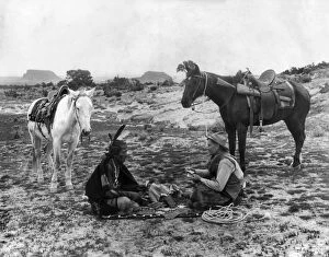 Game Collection: PLAYING CARDS, c1915. A cowboy and a Native American man seated on a blanket