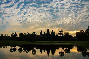 Harvesting Collection: Angkor Wat temple at sunrise reflecting in water