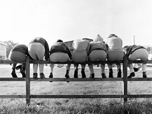 Small Group Of People Collection: Seven young apprentice female jockeys sitting on a wooden fence during their training at